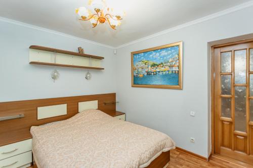 a bedroom with a bed and a painting on the wall at Bright and cozy home with personal terrace in Chişinău
