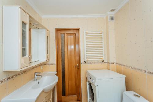 a bathroom with a sink and a washing machine at Bright and cozy home with personal terrace in Chişinău