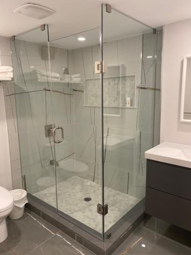 La salle de bains est pourvue d'une douche en verre et de toilettes. dans l'établissement Luxurious and Spacious Apartment with 2 bedrooms and 2 Baths, à Mississauga