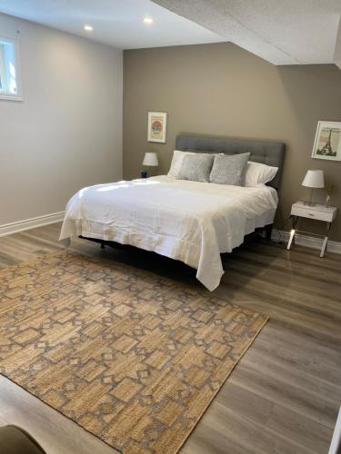 1 dormitorio con 1 cama grande y 1 alfombra en Luxurious and Spacious Apartment with 2 bedrooms and 2 Baths, en Mississauga