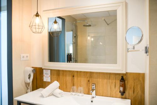 a bathroom with a sink and a mirror at Lloret Vibe Affiliated by FERGUS in Lloret de Mar
