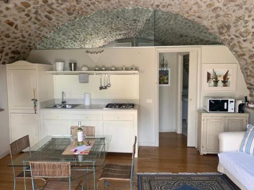 uma cozinha e sala de estar com uma mesa de vidro em La Guarnigione em Valeggio sul Mincio