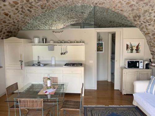 cocina y sala de estar con mesa de cristal en La Guarnigione, en Valeggio sul Mincio