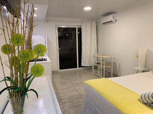 a room with a bed and a vase with flowers at Tu Casita en Aruba in Palm-Eagle Beach