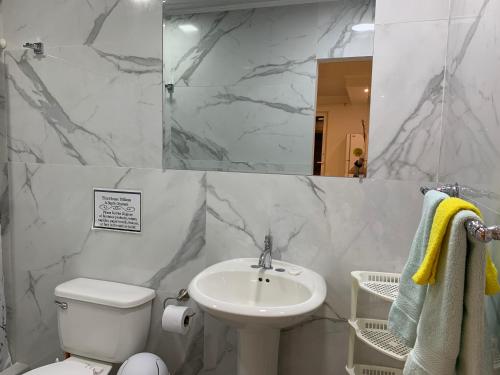 a bathroom with a sink and a toilet and a mirror at Tu Casita en Aruba in Palm-Eagle Beach