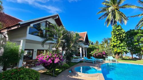 a villa with a swimming pool and palm trees at Laemsor Residence in Laem Sor