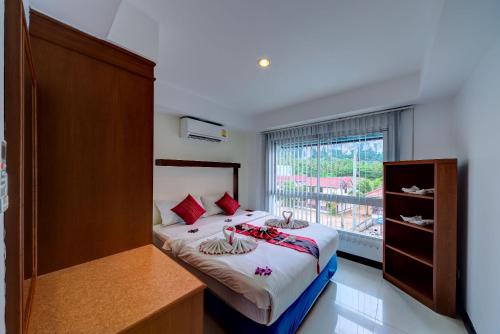 a bedroom with a bed and a large window at Krabi Apartment-SHA Extra Plus in Ao Nang Beach