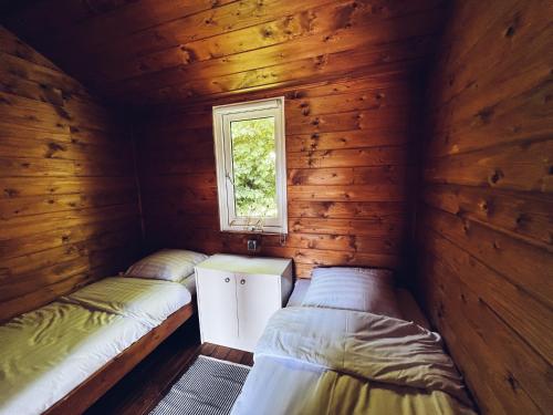 Postel nebo postele na pokoji v ubytování Kampeerhuisje met veranda over de vijver
