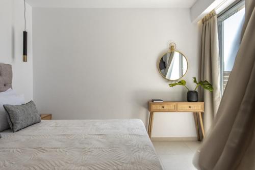 a bedroom with a bed and a mirror and a window at Mystic Garden Villas in Zakynthos Town