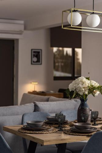 a living room with a table with a vase of flowers at Mystic Garden Villas in Zakynthos Town