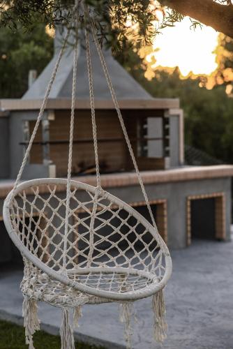 a white basket hanging from a tree in front of a house at Mystic Garden Villas in Zakynthos Town