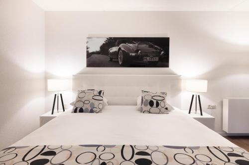 a white bedroom with a white bed with two lamps at Hotel Mitland in Utrecht