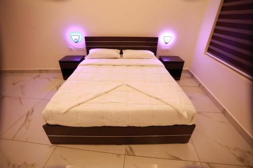 a bedroom with a bed with two night stands and two lamps at Aman Residency in Thodupuzha