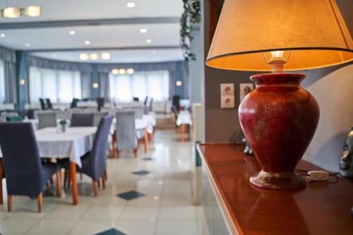 a red lamp sitting on a table in a restaurant at Hotel Korona in Harkány