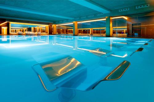 a swimming pool in a hotel with blue lighting at Barceló Costa Vasca in Donostia-San Sebastián