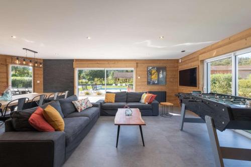 - un salon avec un canapé et un billard dans l'établissement Chalet du Bien-être 15p. Piscine,Spa, Hammam,Pétanque,Basket, à Gérardmer