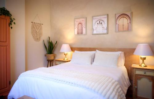 ein Schlafzimmer mit einem großen weißen Bett mit zwei Lampen in der Unterkunft The BeeKeeper's Inn in Louis Trichardt