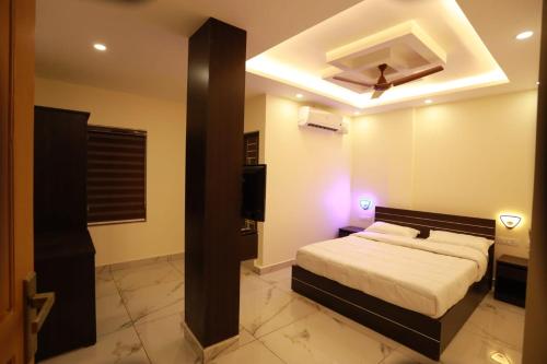 a bedroom with a bed and a ceiling at Aman Residency in Thodupuzha