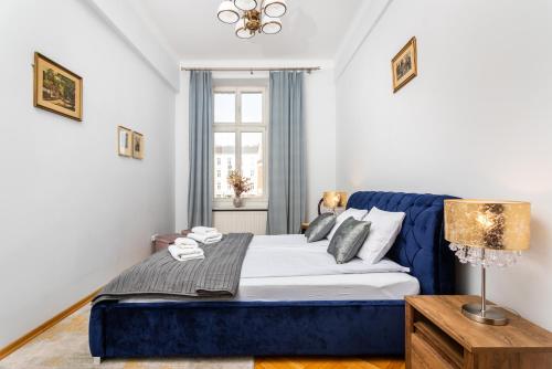 Un dormitorio con una cama azul y una ventana en Plac Nowy Apartments - The Heart of Jewish Quarter, en Cracovia