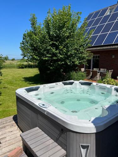 a hot tub in a backyard with solar panels at Wohlfühlvilla Garding in Garding