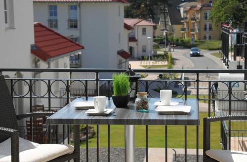 a table on a balcony with a view of a street at Haus Meeresblick - Ferienwohnung Windlicht A 2.08 (Ref. 128696) in Baabe