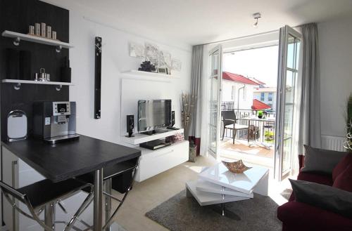 a living room with a table and a tv and a couch at Haus Meeresblick - Ferienwohnung Windlicht A 2.08 (Ref. 128696) in Baabe