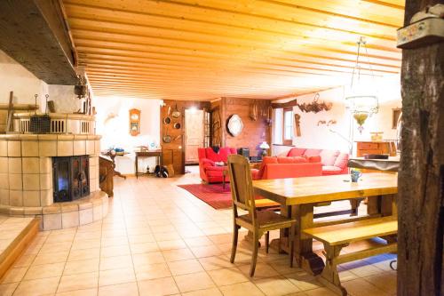 een woonkamer met een tafel en een open haard bij Chalet familial authentique avec jardin/cheminée in Samoëns