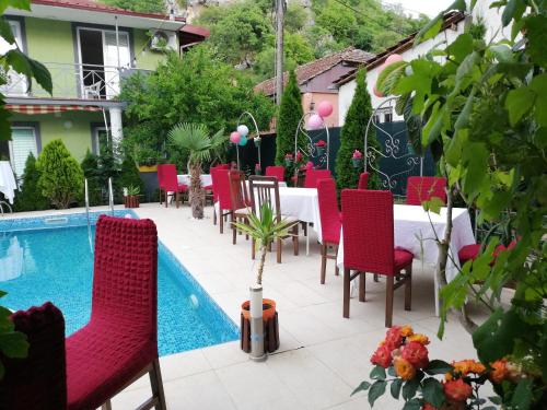 a patio with a table and chairs next to a pool at Lile Pestani Accommodation in Peštani
