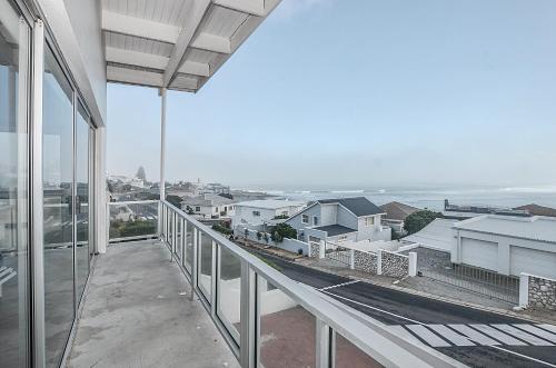 a balcony with a view of the ocean and houses at 13 on Main in Yzerfontein