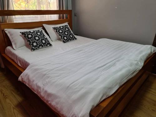 a bed with white sheets and pillows on it at Unia fancy flats 3 bed room apartment- Flat 2 in Kampala