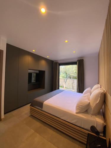 a bedroom with a large bed and a window at Mini-Villa Jade in Bonifacio