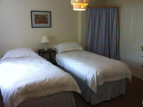 two beds sitting next to each other in a room at Gunville House B&B in Grateley