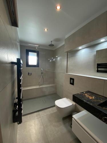 une salle de bain avec toilettes, baignoire et lavabo dans l'établissement Mini-Villa Jade, à Bonifacio