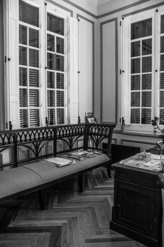 a room with a bench and a table and windows at Hotel Pazo Libunca in Narón