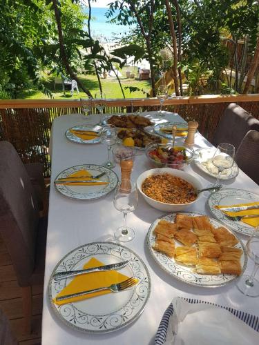 a table with plates of food on top at Vila Thailanda in Katakolo in Pýrgos