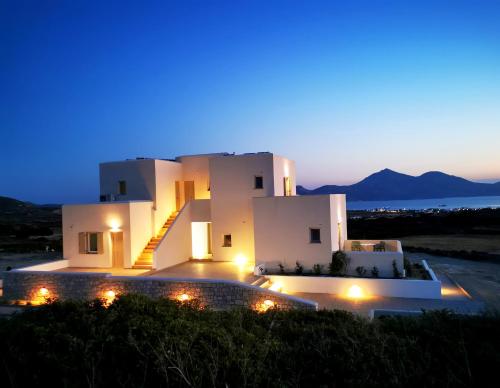 a villa with a view of the ocean at night at Κallisto rooms in Mytakas