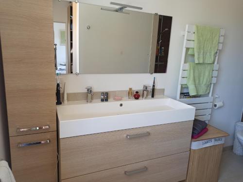 une salle de bain avec un lavabo blanc et un miroir dans l'établissement Laurier, à Cavalaire-sur-Mer