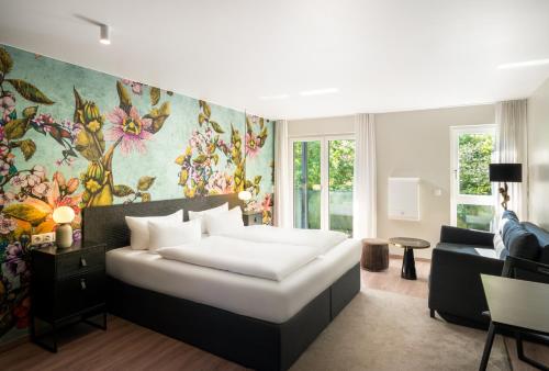 a bedroom with a bed and a living room at ANA Living Karlsruhe by Arthotel ANA in Karlsruhe