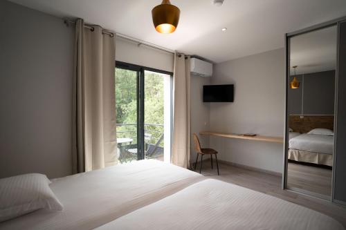 a bedroom with a bed and a sliding glass door at Hôtel Les Vignes in Chassiers