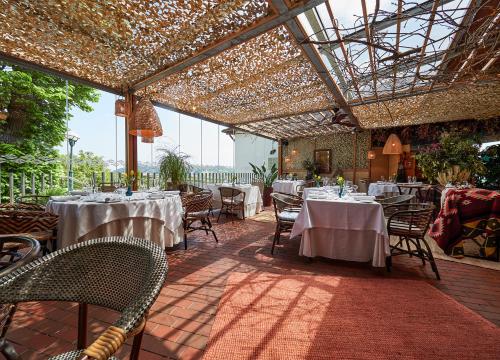 a restaurant with white tables and chairs with lights at La Piconera Hotel & Spa in Ribadesella