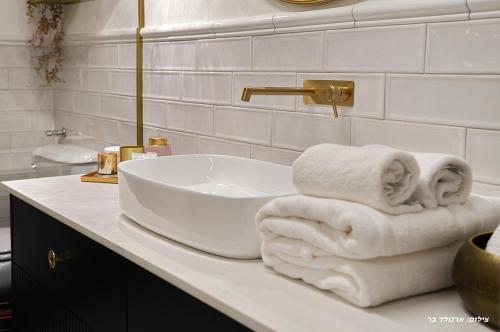 a bathroom with a sink and towels on a counter at מוריה גולד - MORIA GOLD in Manot