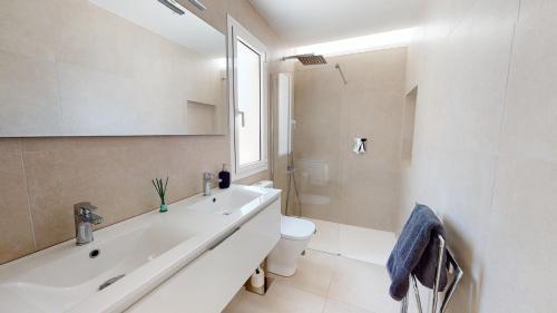 a white bathroom with a sink and a toilet at Villa Higinio - A Murcia Holiday Rentals Property in Santiago de la Ribera