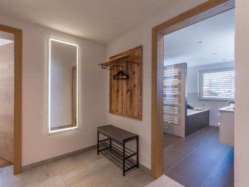 a bathroom with a mirror and a stool in a room at Sonnberg Living Superior Plus in Brixen im Thale