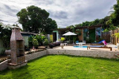 a backyard with a brick retaining wall and a patio at Raízes de Noronha in Fernando de Noronha