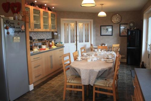 a kitchen with a table with chairs and a refrigerator at Asgard B&B in Stromness