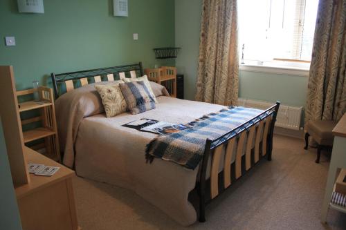 a small bedroom with a bed and a window at Asgard B&B in Stromness