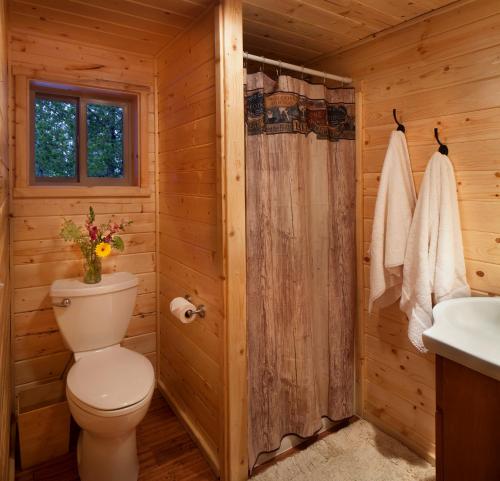 a log cabin bathroom with a toilet and a sink at Reclusive Moose Cabins in West Glacier