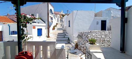 a narrow street with white buildings and a stone wall at Cycladic Maisonette (Dryopida, Kythnos) in Kithnos