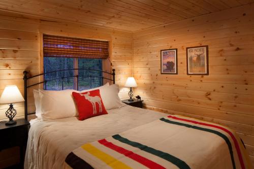 a bedroom with a bed in a log cabin at Reclusive Moose Cabins in West Glacier