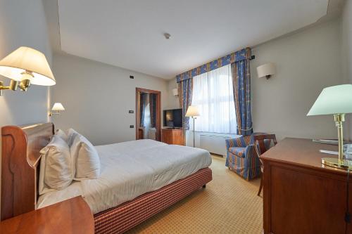 a hotel room with a bed and a desk at Relais Santo Stefano in Sandigliano